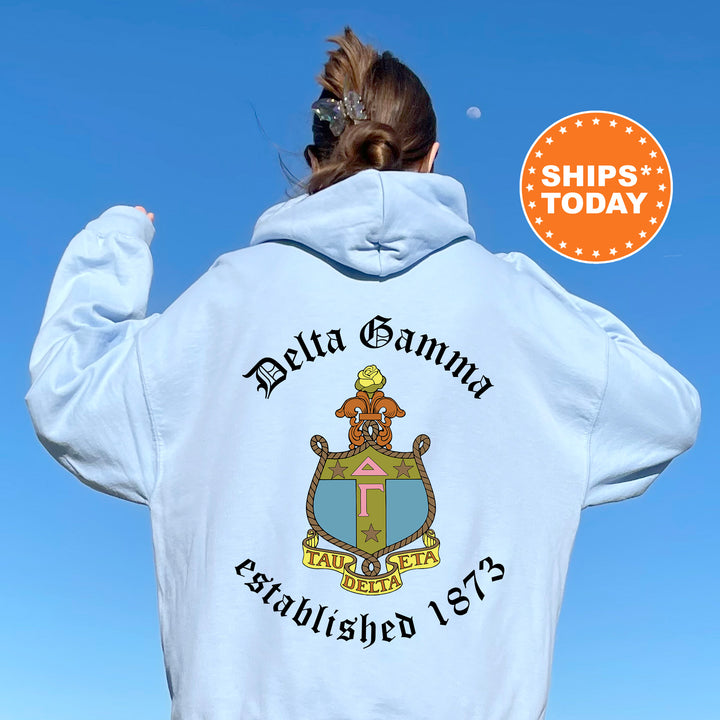 a woman wearing a white hoodie with a crest on it