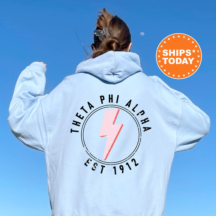 a woman wearing a white hoodie with a pink lightning bolt on it