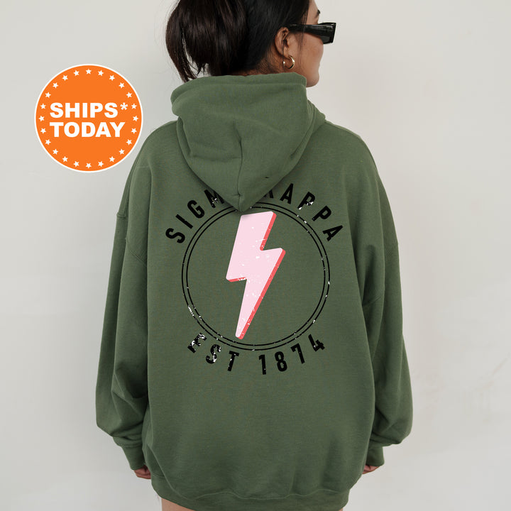 a woman wearing a green hoodie with a pink lightning bolt on it