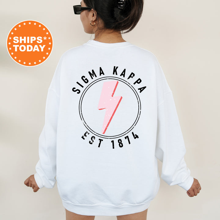 a woman wearing a white sweatshirt with a pink lightning bolt on it