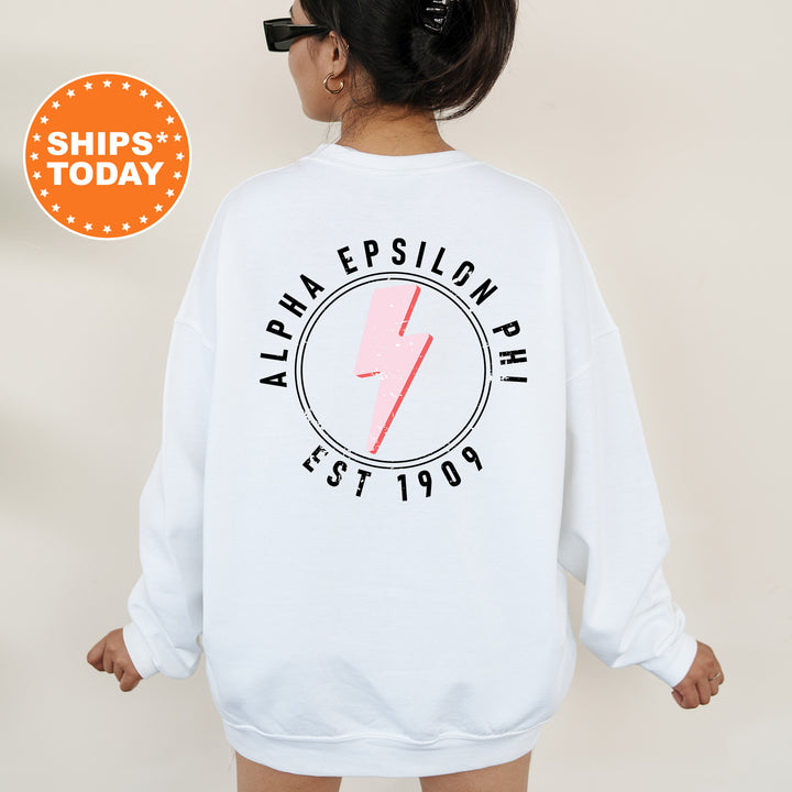 a woman wearing a white sweatshirt with a pink lightning bolt on it