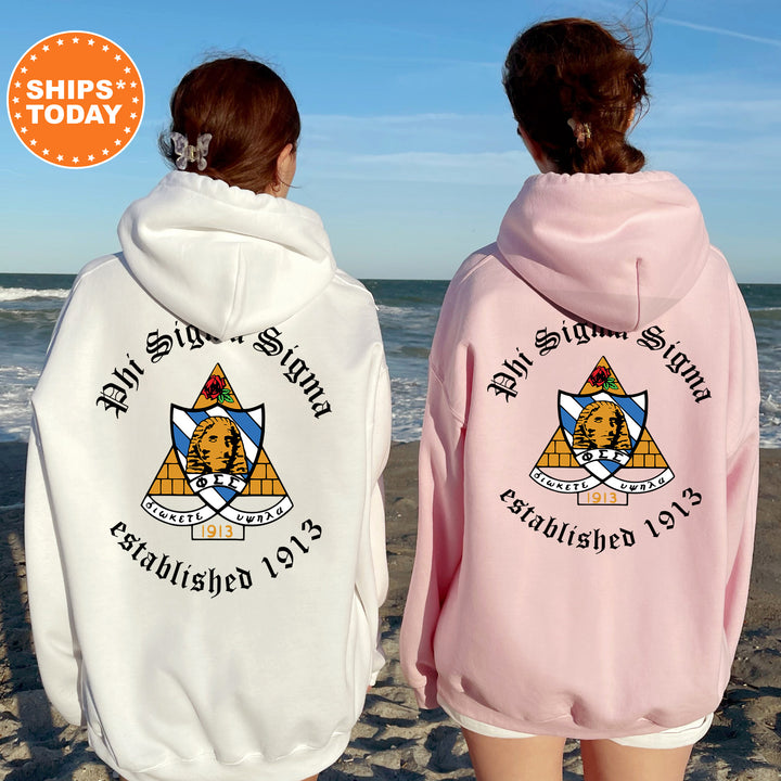 two women wearing pink and white hoodies on the beach