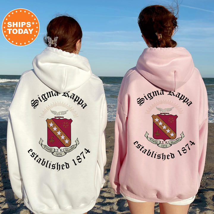 two women wearing pink and white hoodies on the beach
