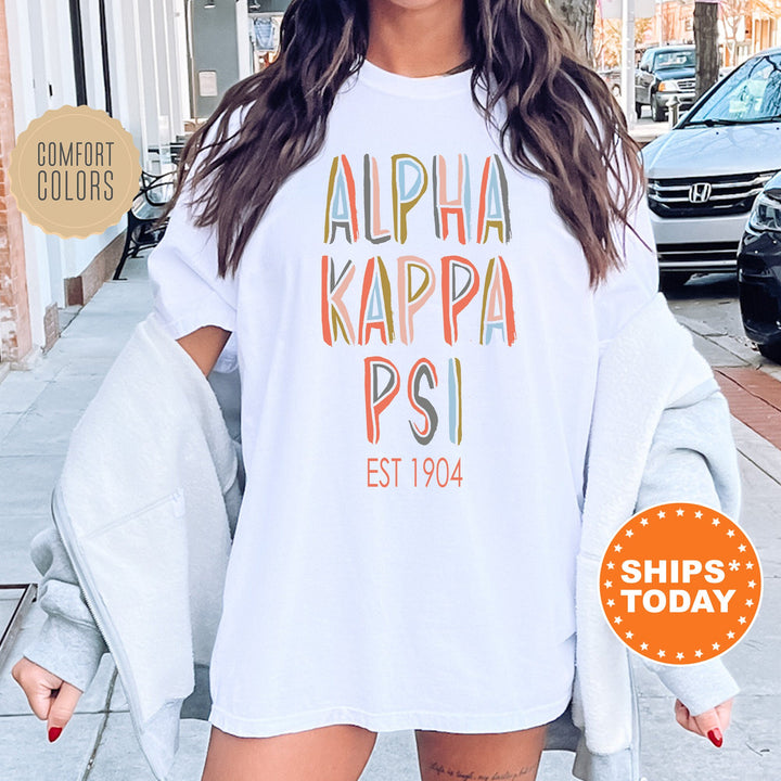 Alpha Kappa Psi Pastel Stencil Coed T-Shirt | AKPsi Comfort Colors Shirt | Fraternity Apparel | Bid Day Gift | Custom Greek Apparel _ 8831g