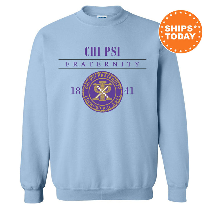 a light blue crew neck sweatshirt with a purple and gold emblem