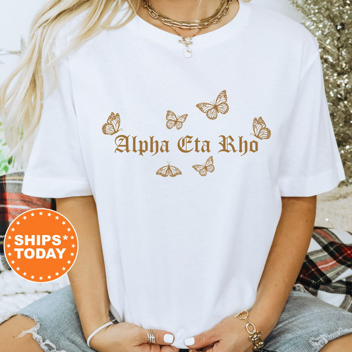 a woman wearing a white shirt with butterflies on it