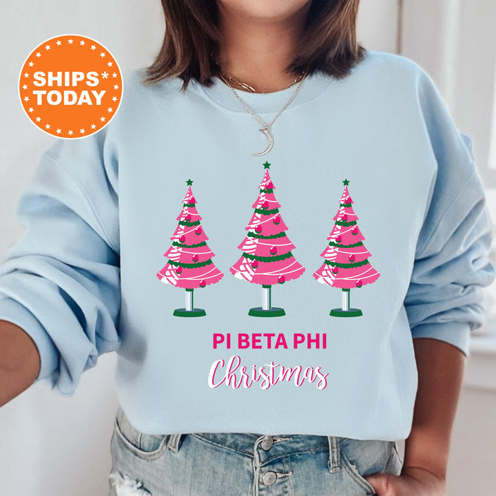 a woman wearing a blue sweatshirt with pink christmas trees on it