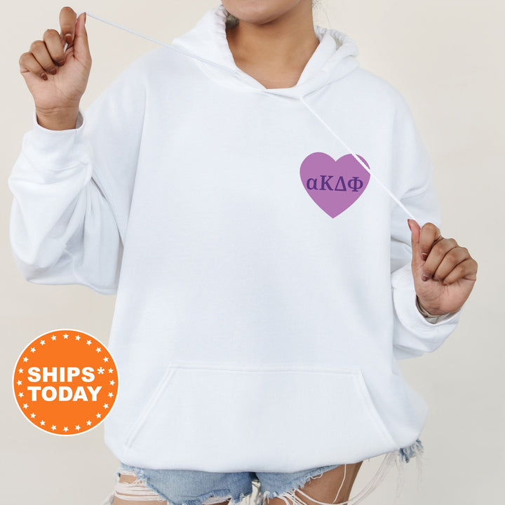 a woman wearing a white hoodie with a purple heart on it