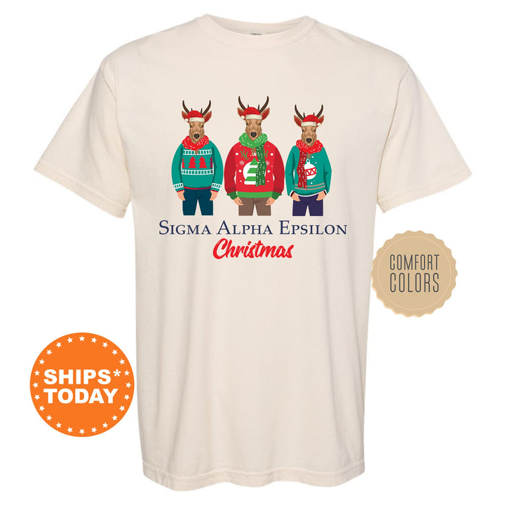 a white t - shirt with three reindeers wearing ugly sweaters