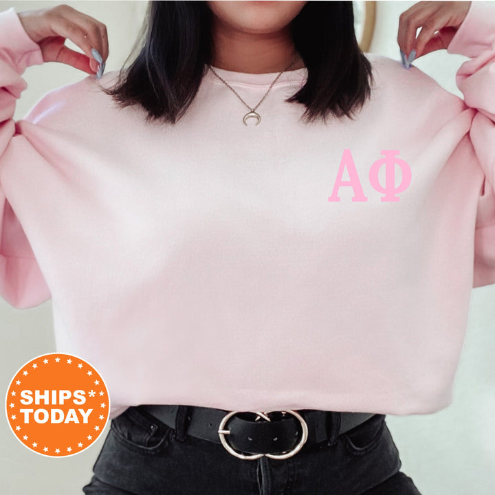 a woman wearing a pink sweatshirt with a phi phi symbol on it