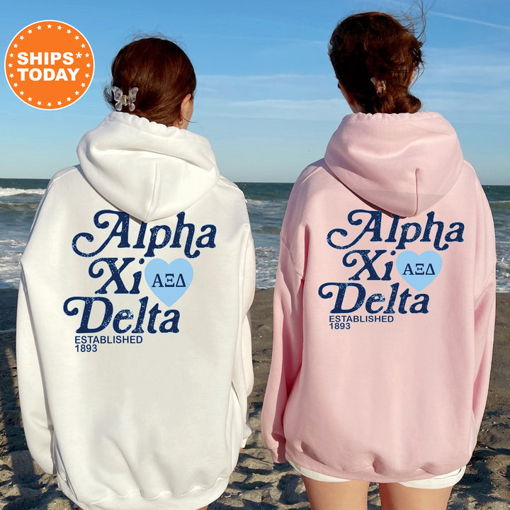 two women wearing pink and white sweatshirts on the beach