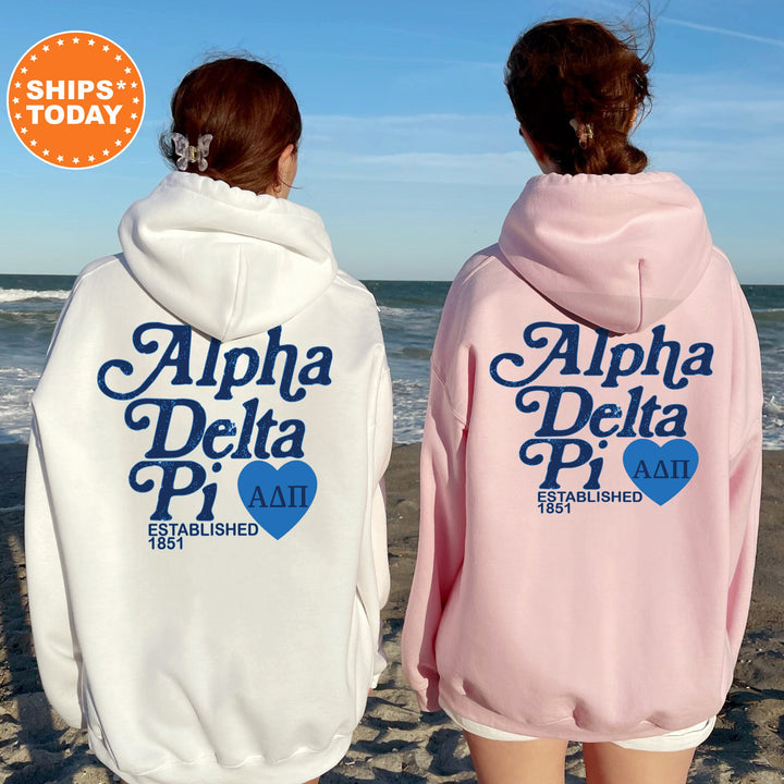 two women wearing matching sweatshirts on the beach