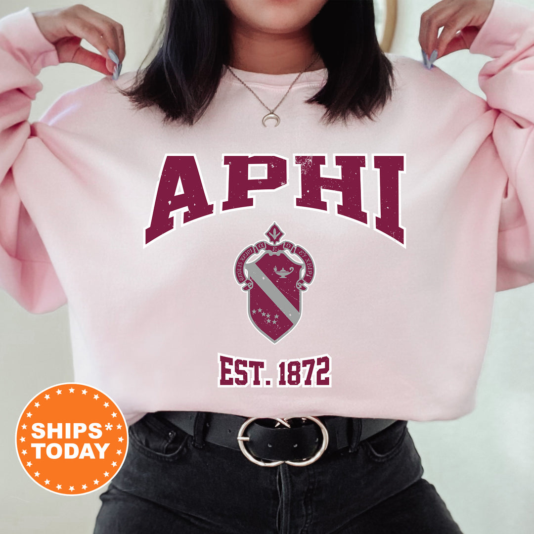 a woman wearing a pink sweatshirt with the words aphi on it