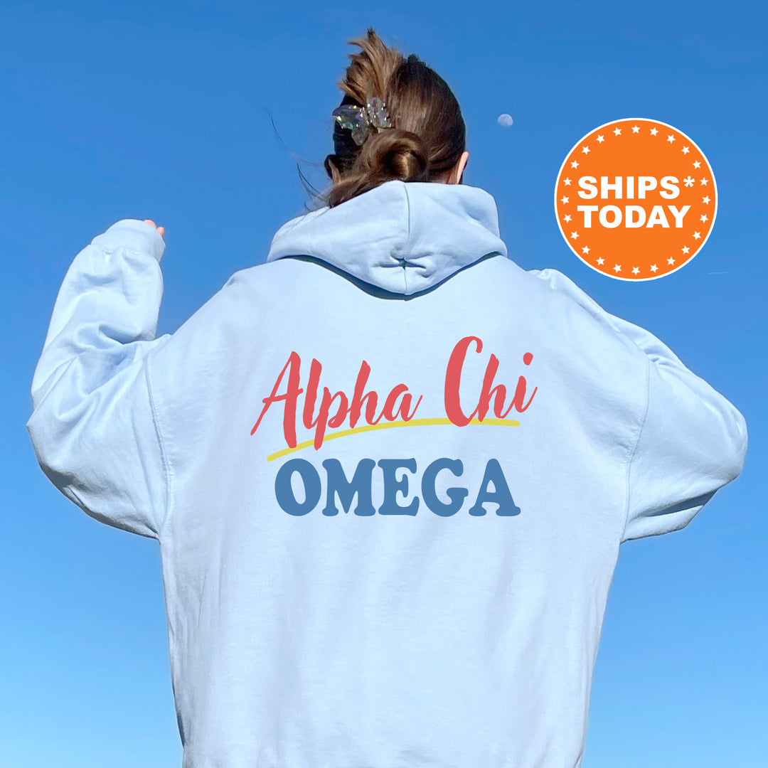 A person wearing a white hoodie with the text "Alpha Chi Omega" printed on it, standing against a clear blue sky.