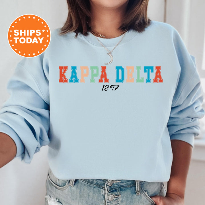 a woman wearing a blue sweatshirt with the words kapa delta printed on it