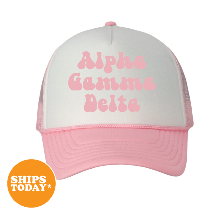 A pink and white baseball cap with the text "Alpha Kappa Delta" printed on it.