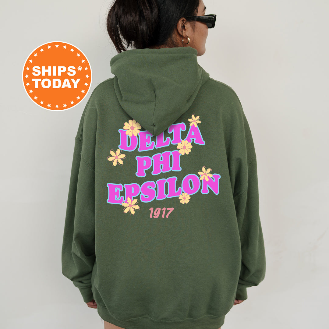 A person wearing a green hoodie with text and flowers printed on it.