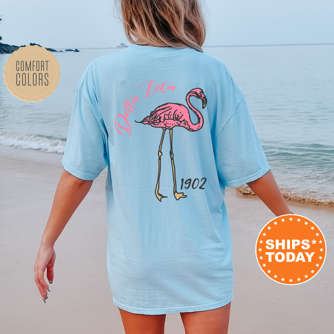 a woman walking on the beach with a pink flamingo t - shirt