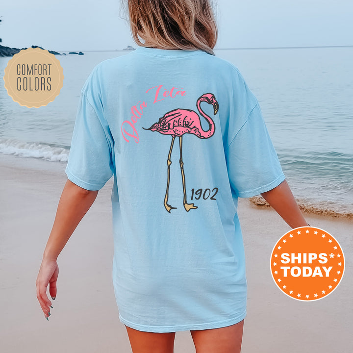 a woman walking on the beach with a pink flamingo t - shirt