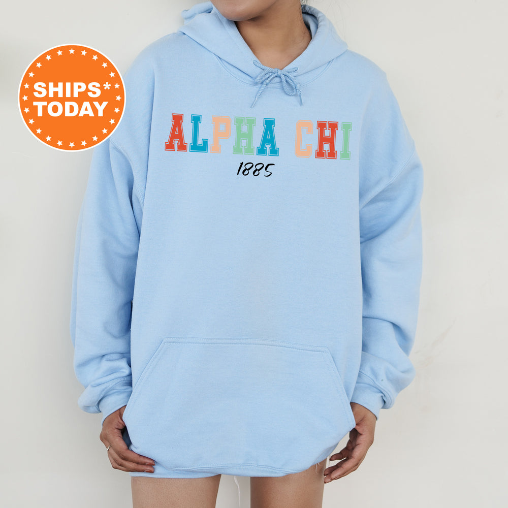 a woman wearing a light blue hoodie with the words alpha chi on it