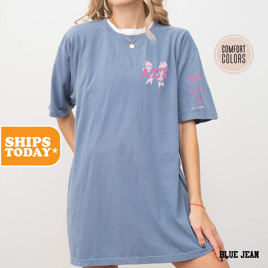 a woman wearing a blue shirt dress with pink bows on it