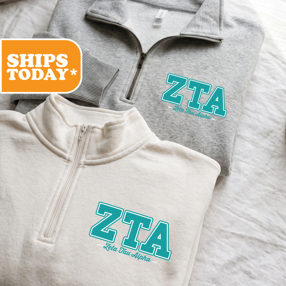 Two gray zip-up sweatshirts with the text "ZTA Let's Alpha" printed on them, along with a "SHIPS TODAY" logo in the top left corner.