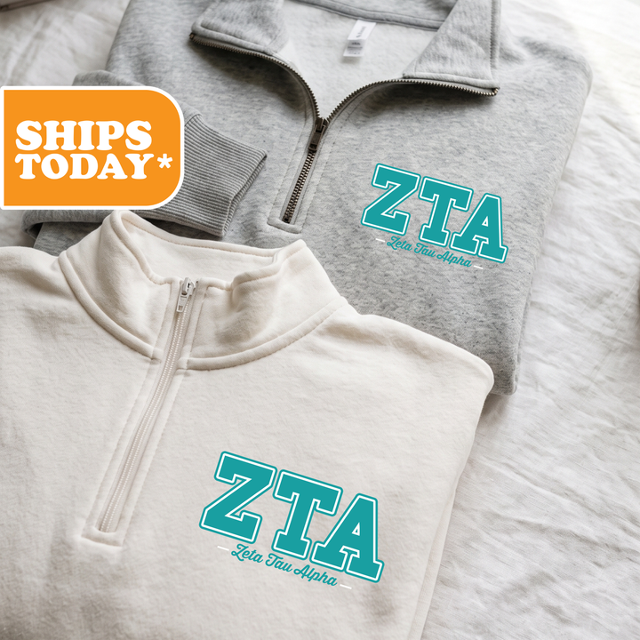 Two gray zip-up sweatshirts with the text "ZTA Let's Alpha" printed on them, along with a "SHIPS TODAY" logo in the top left corner.