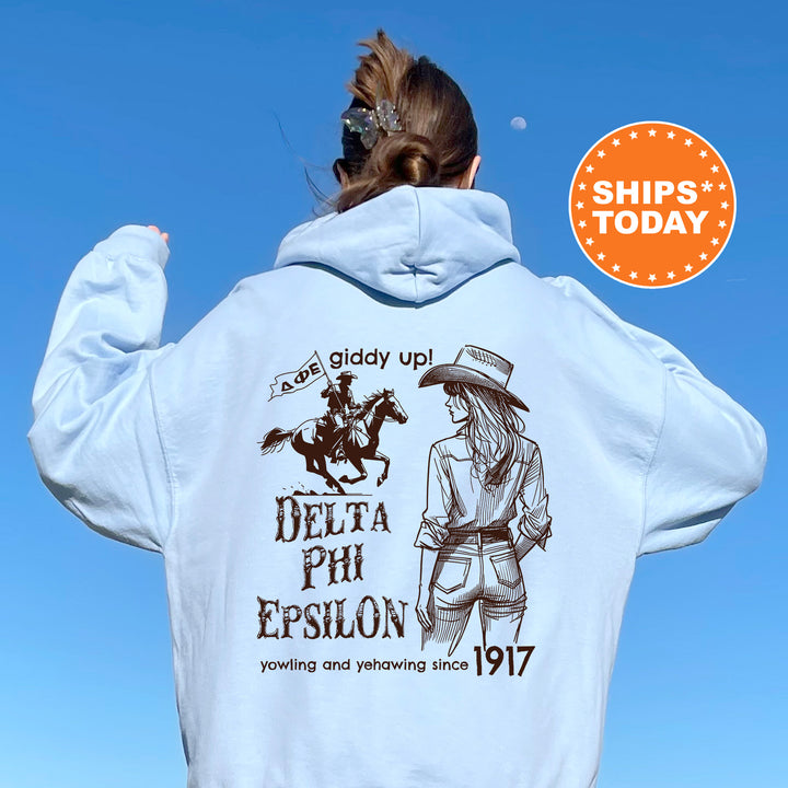 a woman wearing a white hoodie with a picture of a woman riding a horse