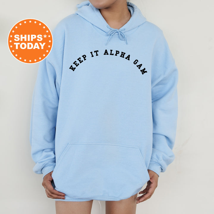 a woman wearing a light blue hoodie with the words keep it alpa san