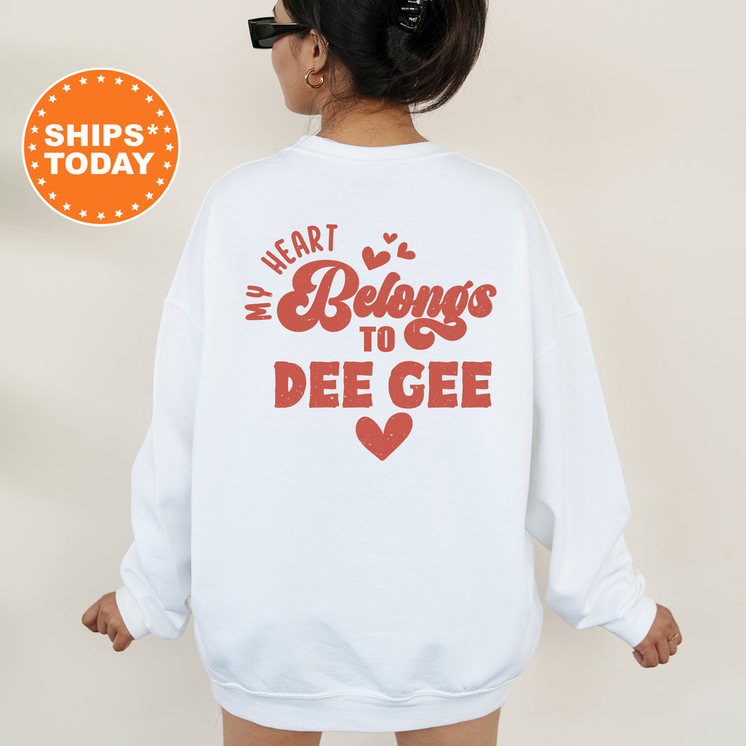 a woman wearing a white sweatshirt that says heart belongs to deegee