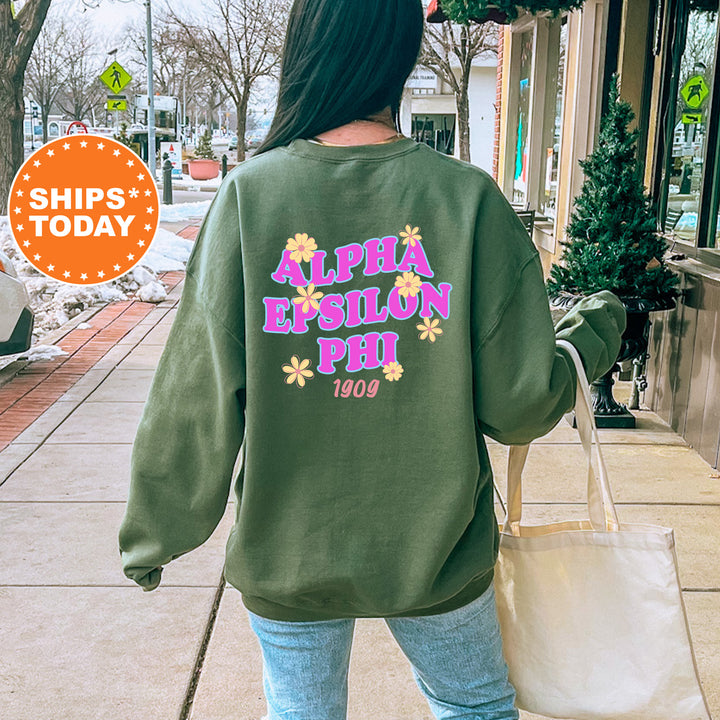 A person wearing a green sweatshirt with the text "ALPHA EPSILON PHI" printed on it, walking down a city street.