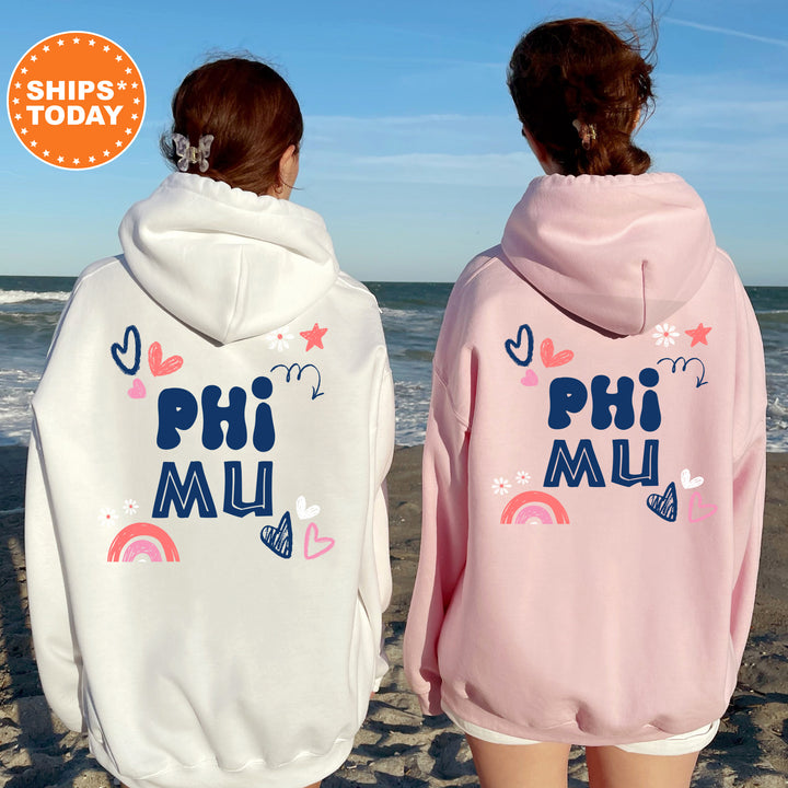 two girls wearing pink and white sweatshirts on the beach