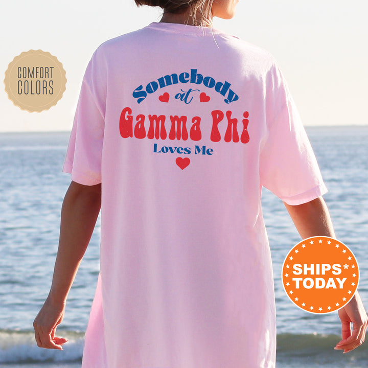 a woman standing on a beach wearing a pink shirt