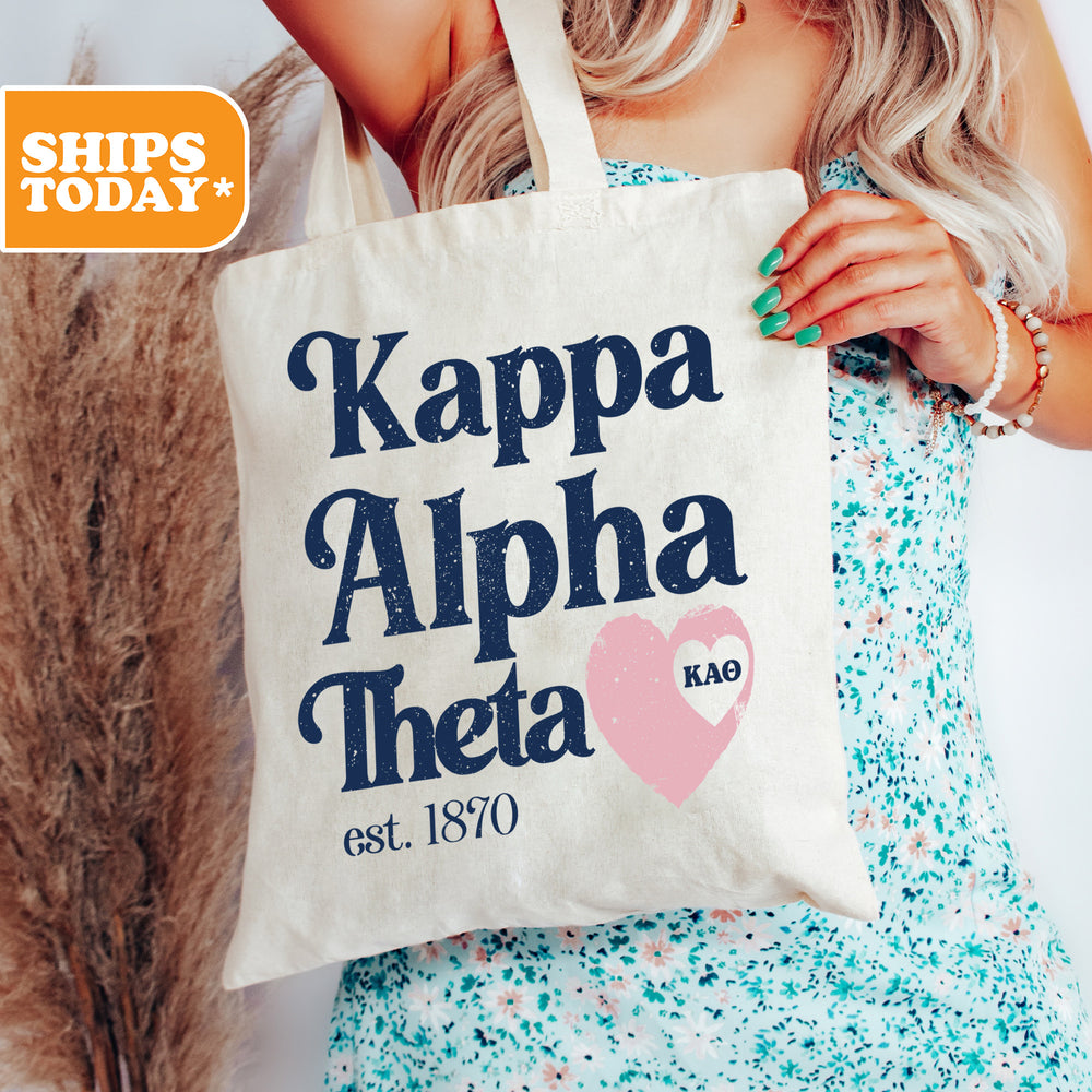 a woman holding a tote bag that says kappa alpha thea