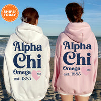 two women wearing matching sweatshirts on the beach