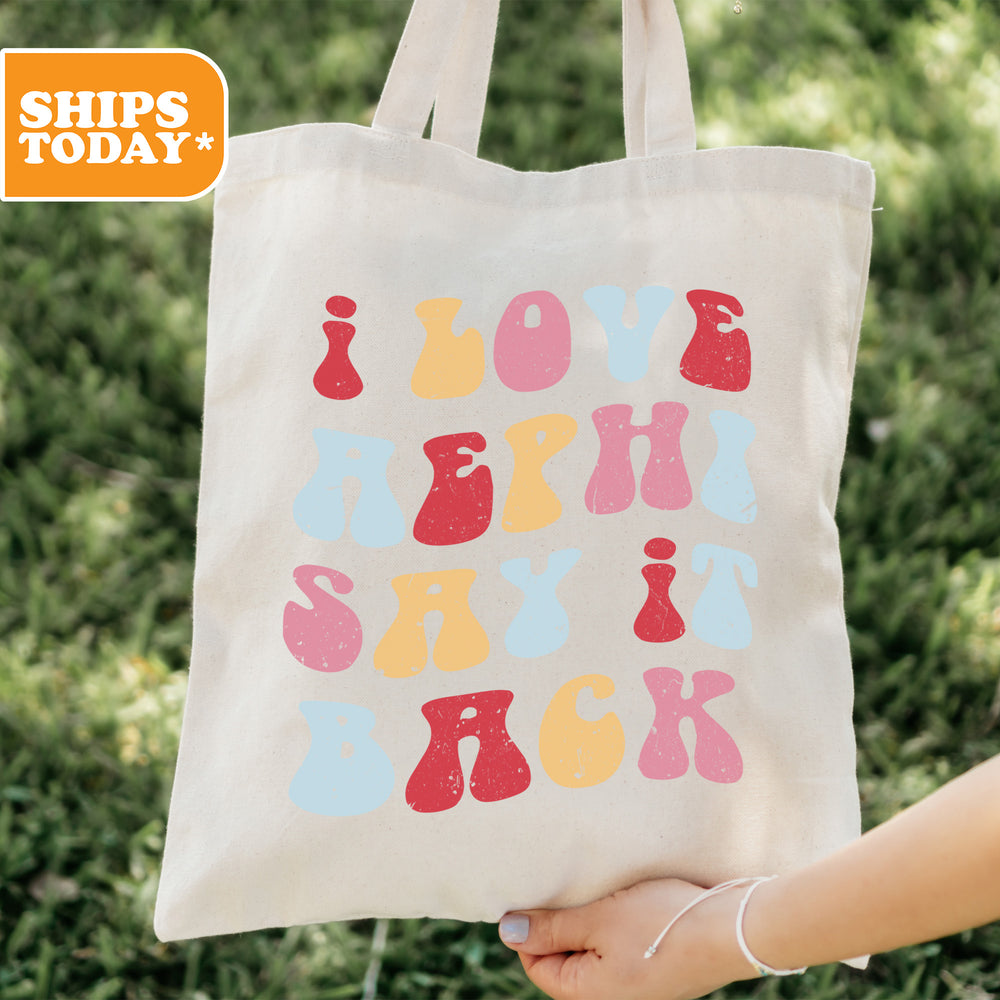 a person holding a tote bag with the words love, laugh, and rock