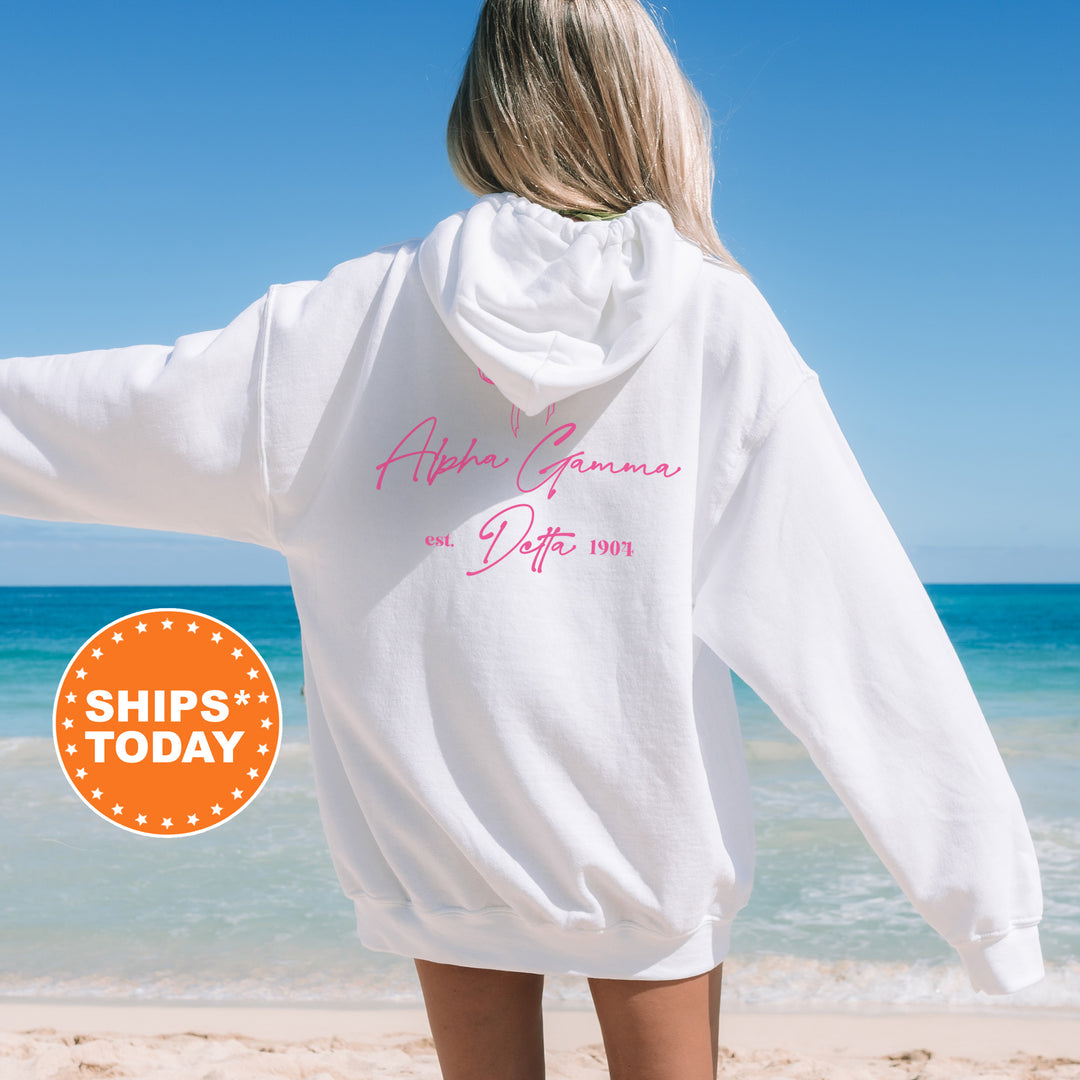 a woman standing on a beach wearing a white sweatshirt