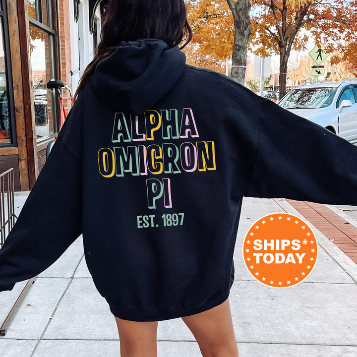 a woman walking down a sidewalk wearing a black hoodie