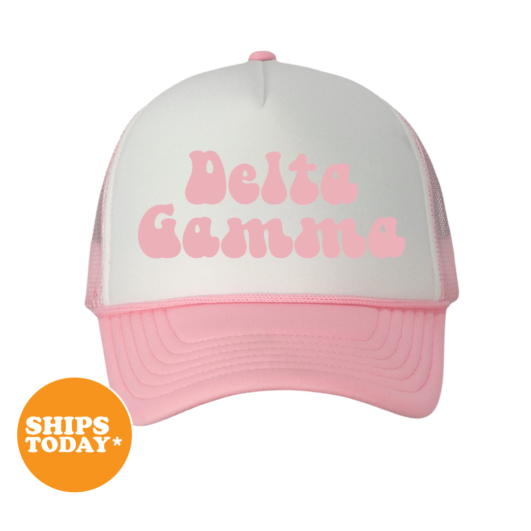A white and pink baseball cap with the text "Delta Gamma" printed on it.