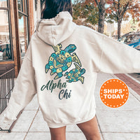 A person wearing a white hoodie with a graphic of a turtle and the text 
