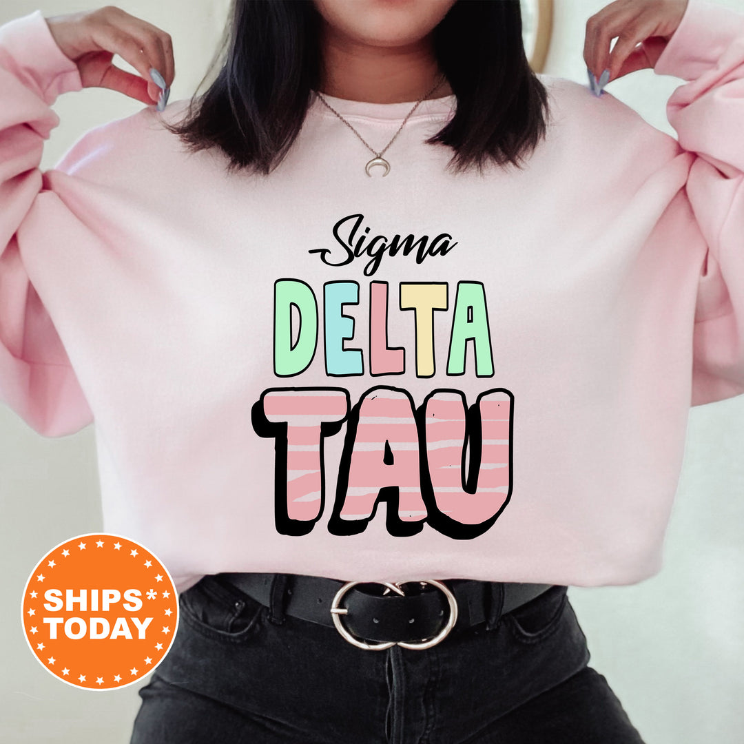 a woman wearing a pink sweatshirt with the word delta tau printed on it