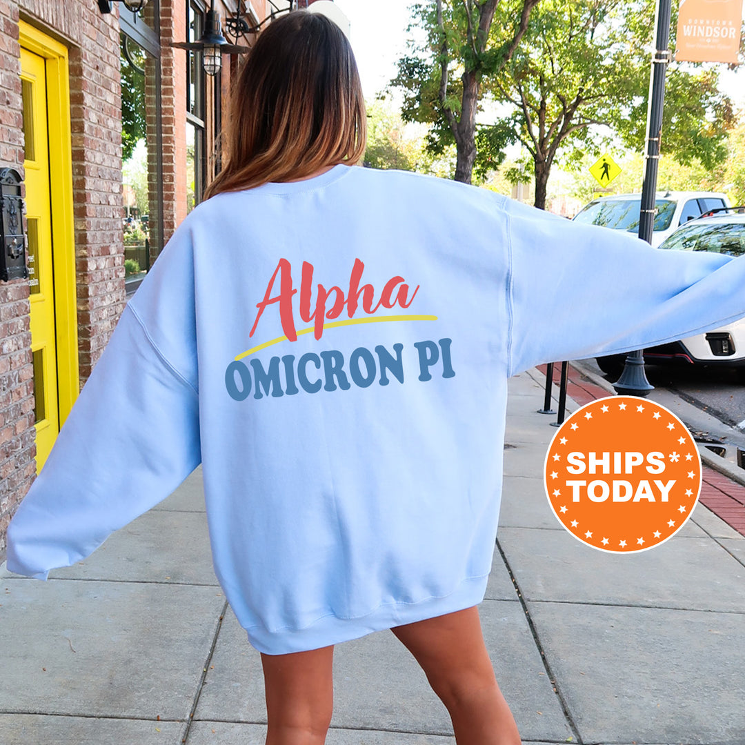 A woman wearing a light blue sweatshirt with text on the back is standing on a sidewalk.