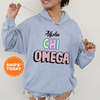 a woman wearing a blue hoodie with the words alpena chi omega on