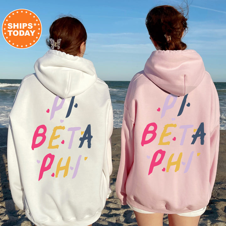 two women in matching sweatshirts on the beach