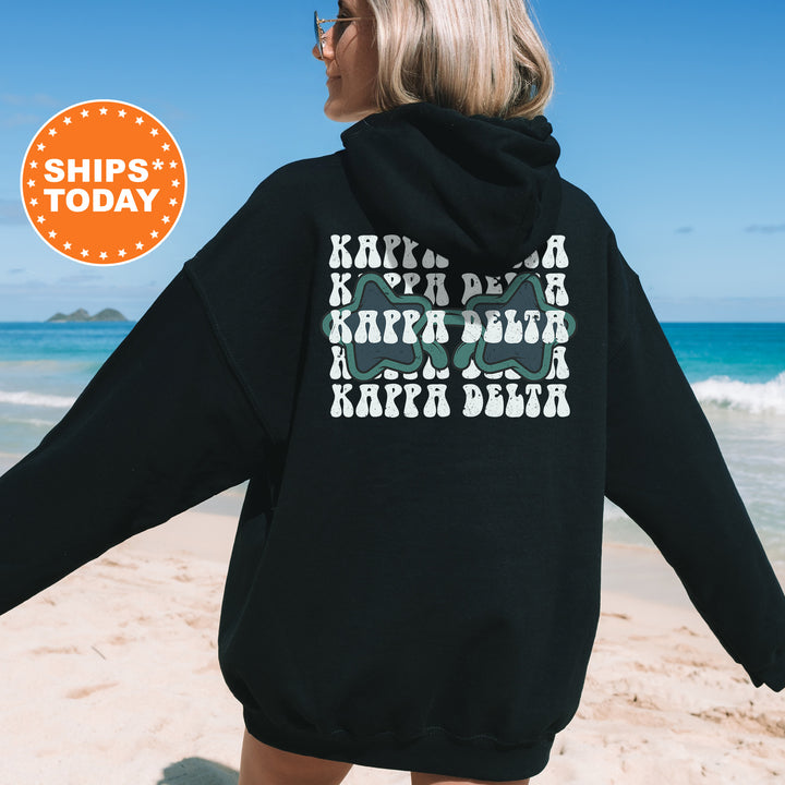 a woman in a black hoodie on the beach