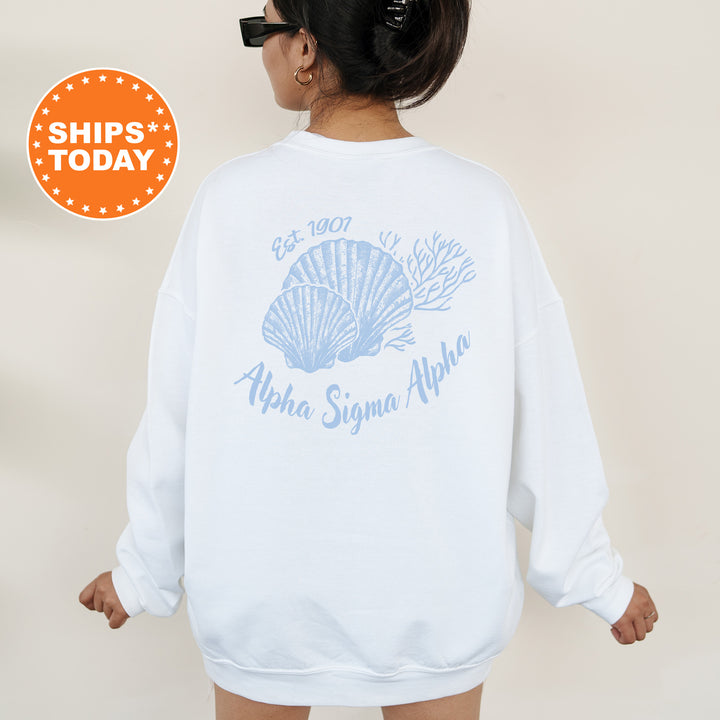 A woman wearing a white sweatshirt with a blue design and text on the back.
