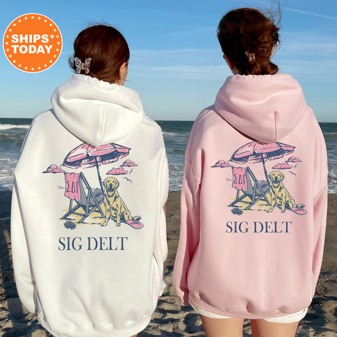 two women wearing pink and white sweatshirts on the beach