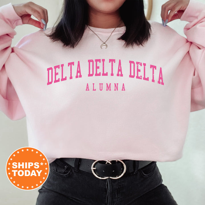 a woman wearing a pink delta delta sweatshirt