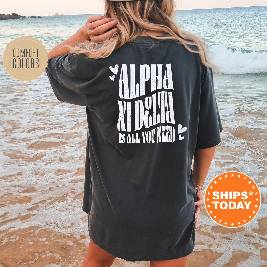 a woman standing on a beach wearing a black shirt