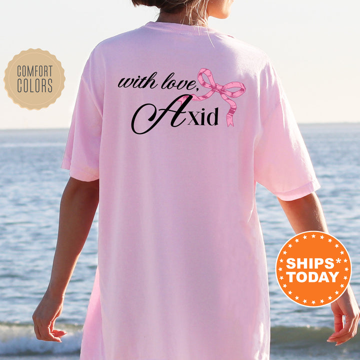 a woman standing on a beach wearing a pink shirt